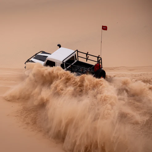 4x4 dune safety flag in action – vehicle cutting through sand dune with mounted 2-piece flag