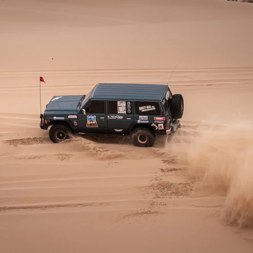 4x4 dune safety flag mounted at front – vehicle cutting through sand dune with 2-piece collapsible pole